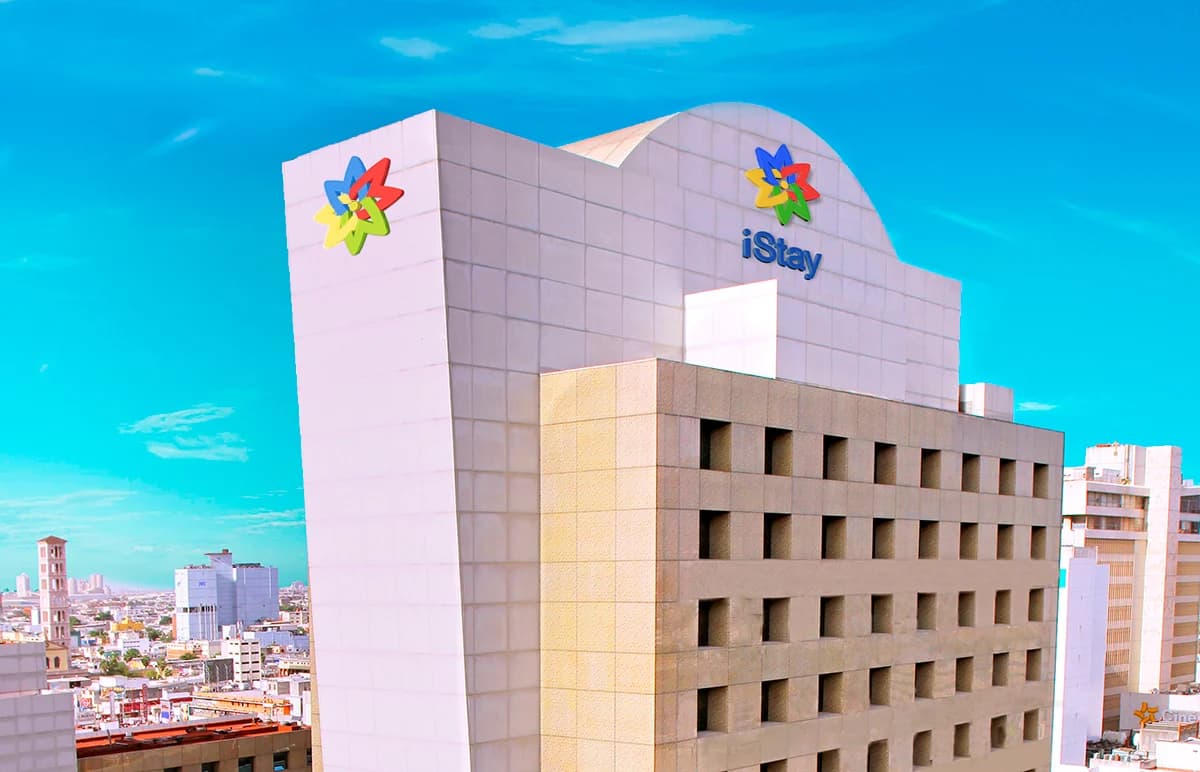 Fachada de iStay Hotel Monterrey Histórico con el centro de la ciudad al fondo