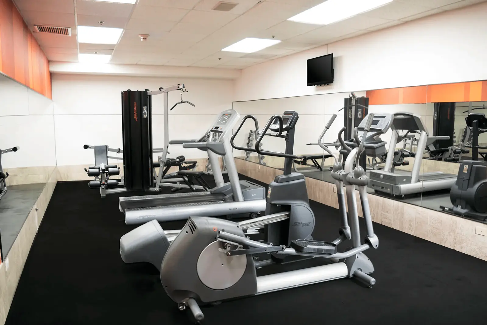 Gimnasio equipado con caminadoras y aparatos de fuerza